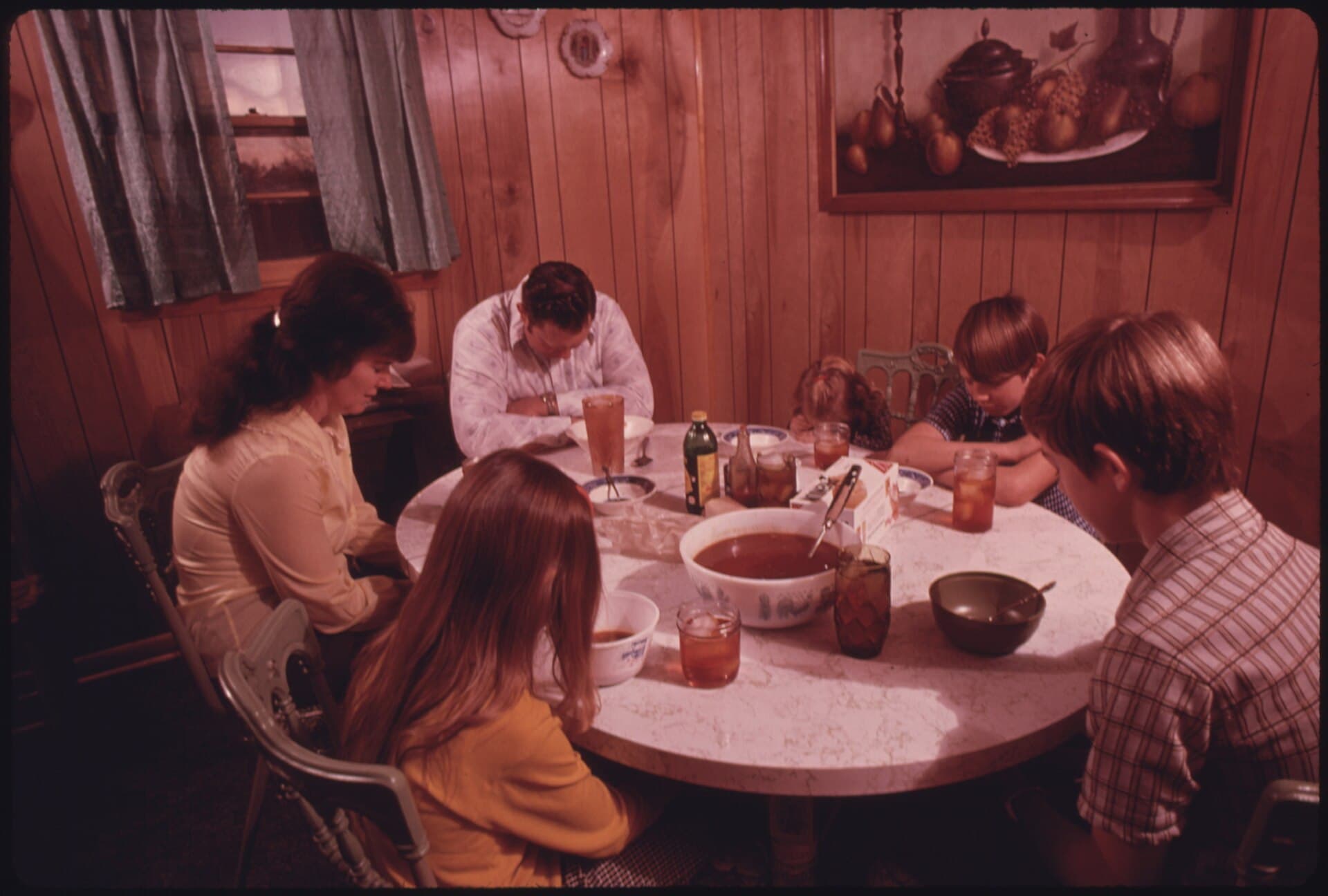 Família reunida em oração antes da refeição