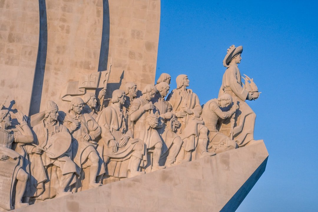 low angle photography of concrete statues under blue sky during daytime