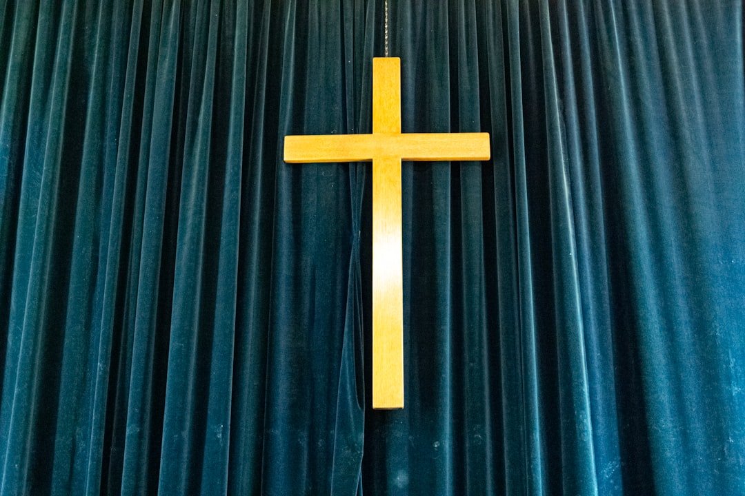 a cross hanging from the side of a curtain