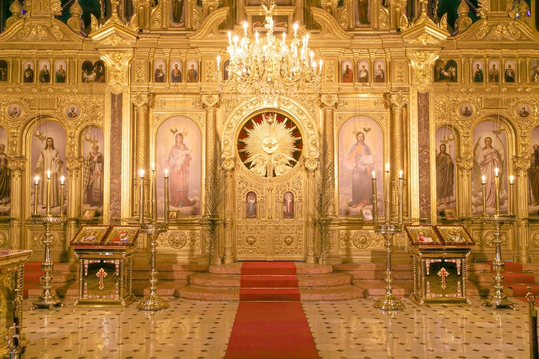 a church with a chandelier and a red carpet