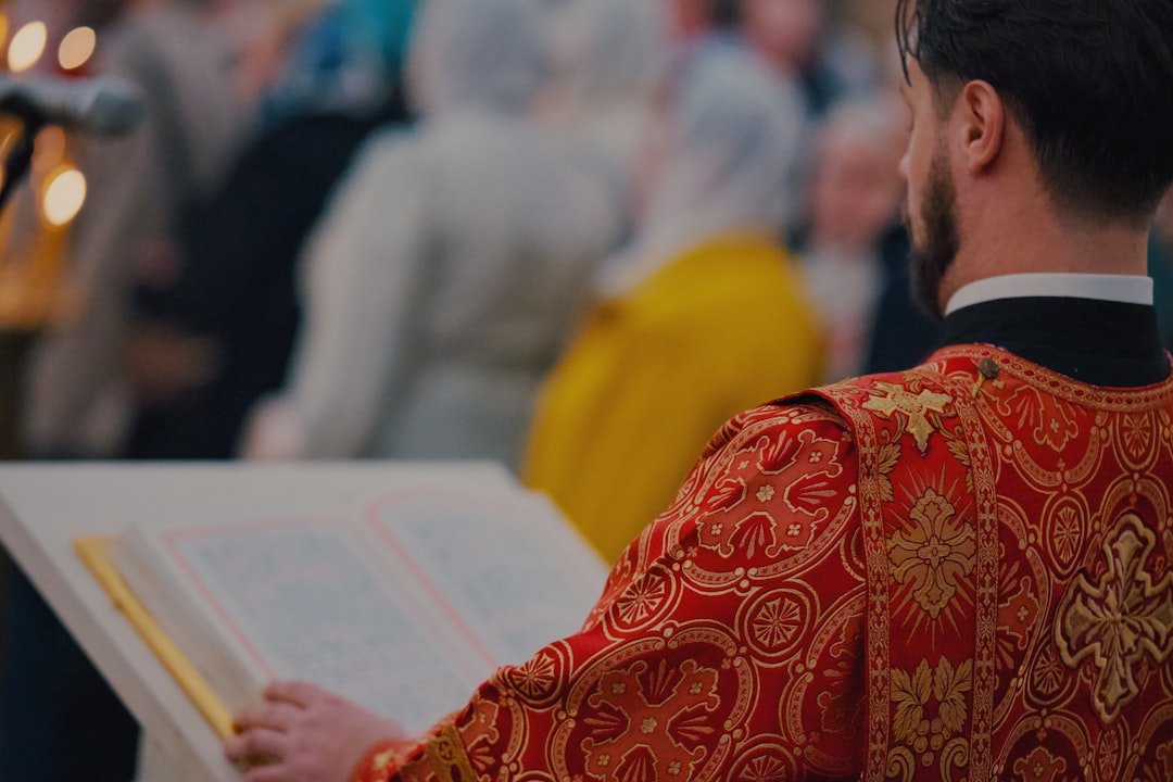 A priest reads from a book during a ceremony.