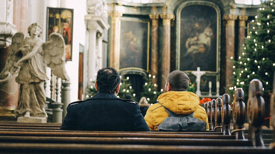 Two people sit in church, contemplating.
