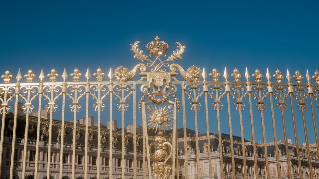 A gilded gate shimmers under a clear sky.