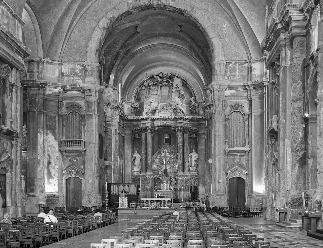 Inside of a cathedral with rows of pews.