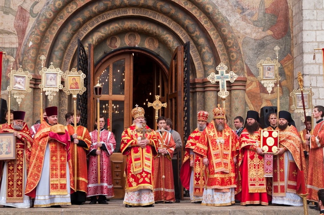 Orthodox priests in ornate robes stand outside church