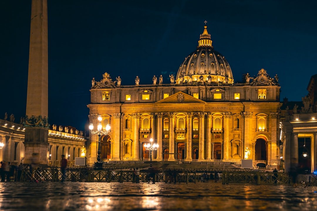 St. peter's basilica illuminated at night with an obelisk.